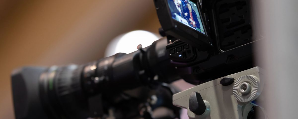 Corporate videographer filming using a broadcast quality camera.